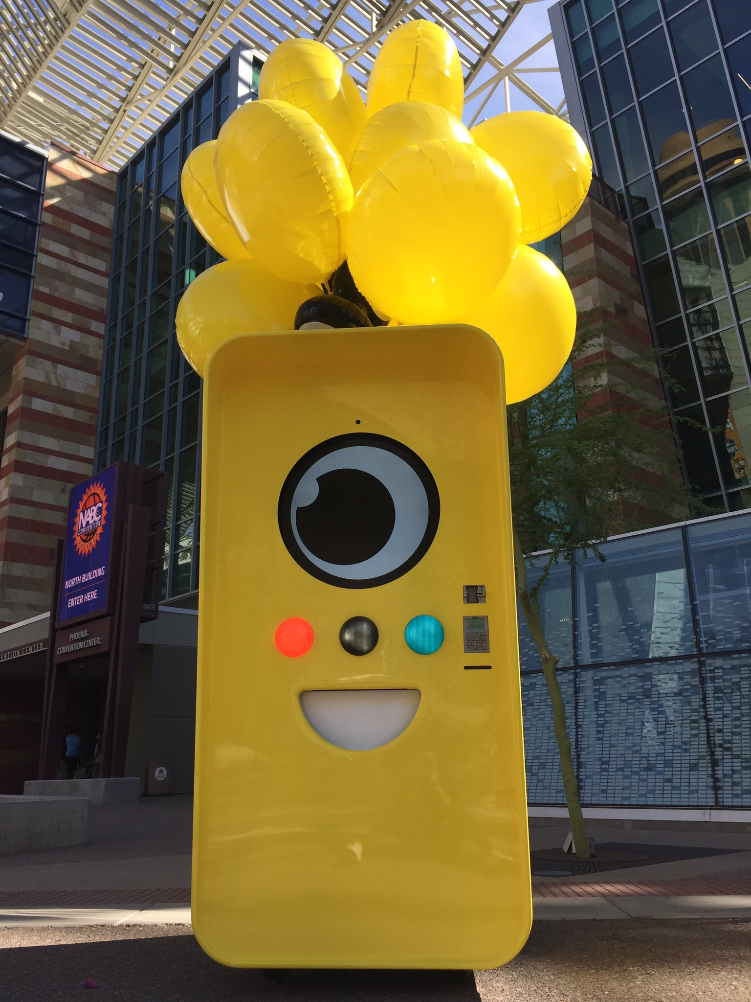 Yellow Snapbot Spectacles vending machine with a bunch of yellow balloons outside Phoenix Convention Center
